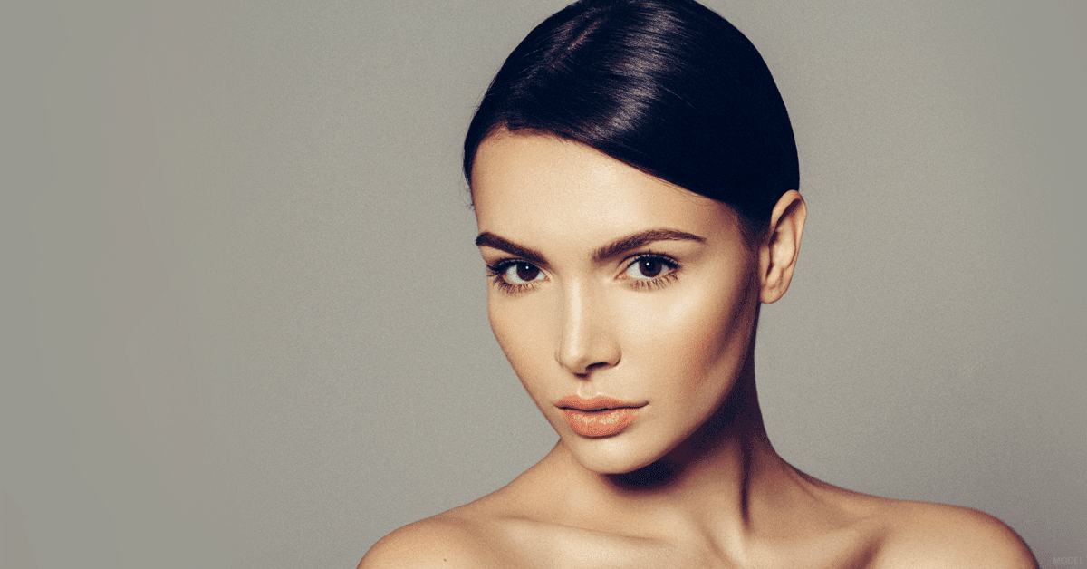 Dark-haired woman with smooth skin looking at camera