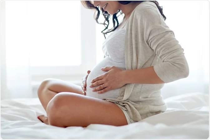 pregnant woman sitting on bed